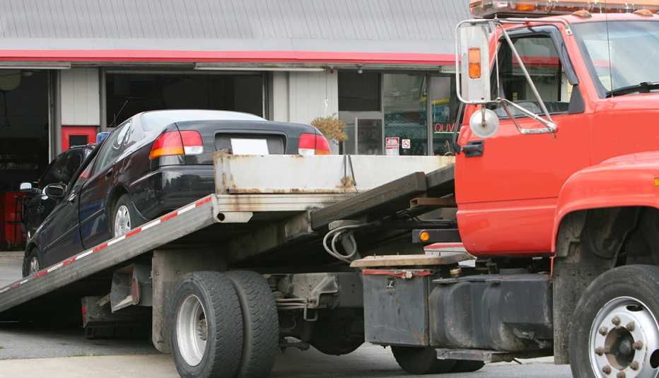 Grúa descarga un carro en un taller de mecánica
