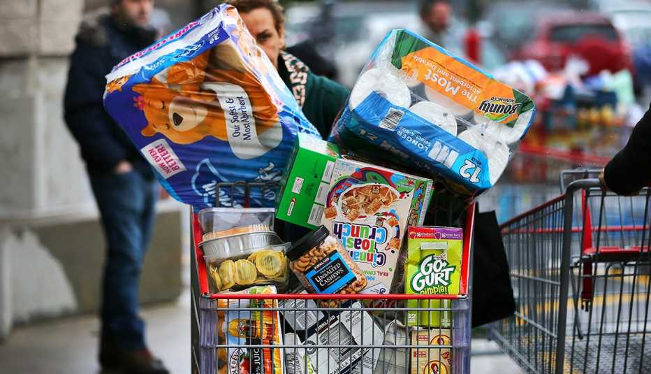 Una persona arrastra un carro lleno de productos al por mayor a las afueras de Costco
