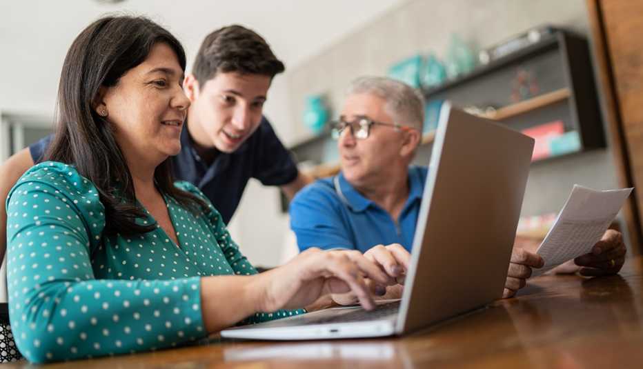 Papás con su hijo hablando de finanzas frente a una computadora