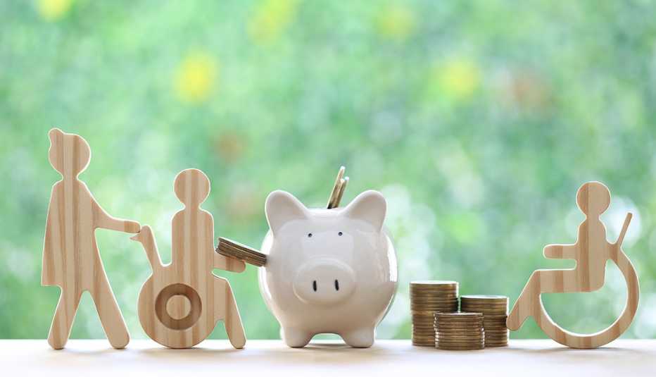 figuras en madera de personas con discapacidades a los lados de una alcancía y monedas