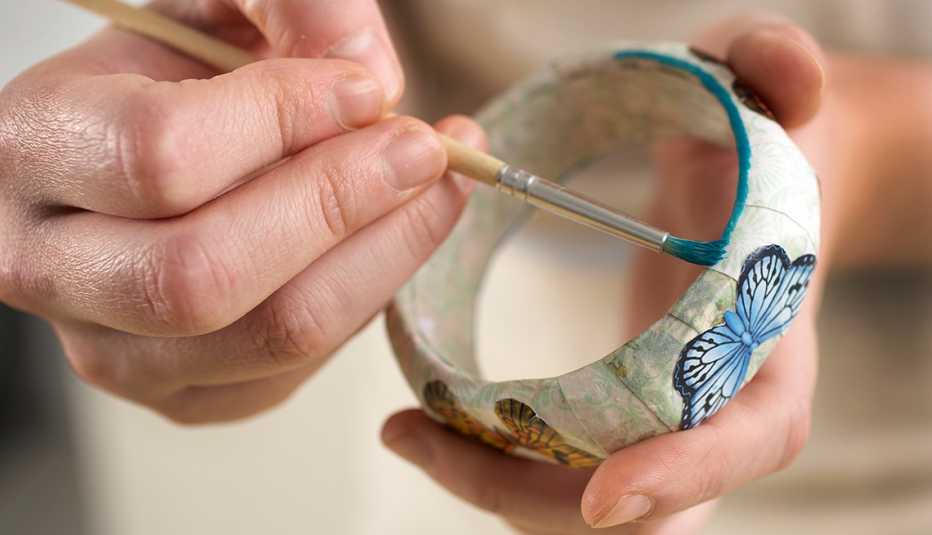 Manos pintando una pulsera