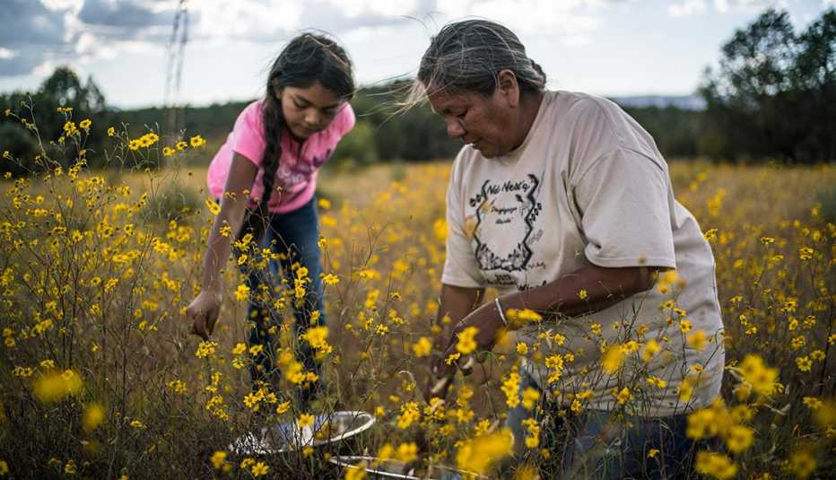 Una niña y una mujer recogen flores y plantas en una escena del documental Gather.