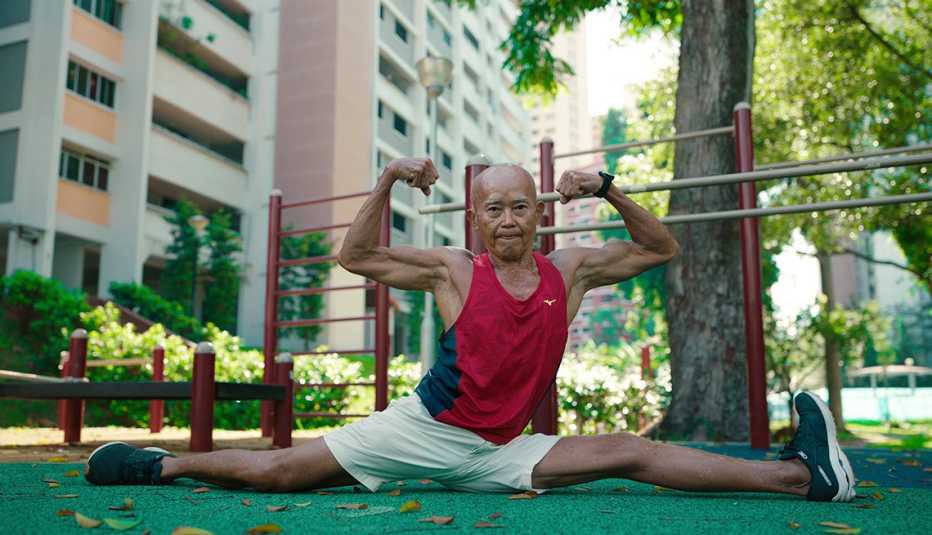 Una hombre flexiona sus brazos en un parque en una escena de "Live to 100: Secrets of the Blue Zones".
