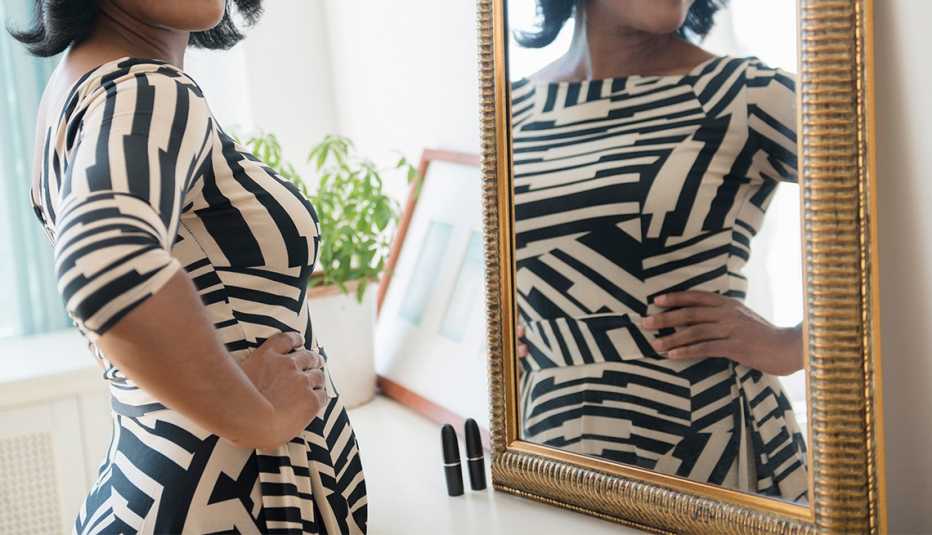 Mujer con un vestido ceñido en la parte superior y en la parte de abajo. Moda para lucir una vientre o panza abultado.