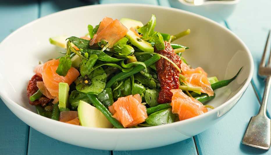 Una ensalada de verano saludable con salmón ahumado, verduras, tomates y aguacate