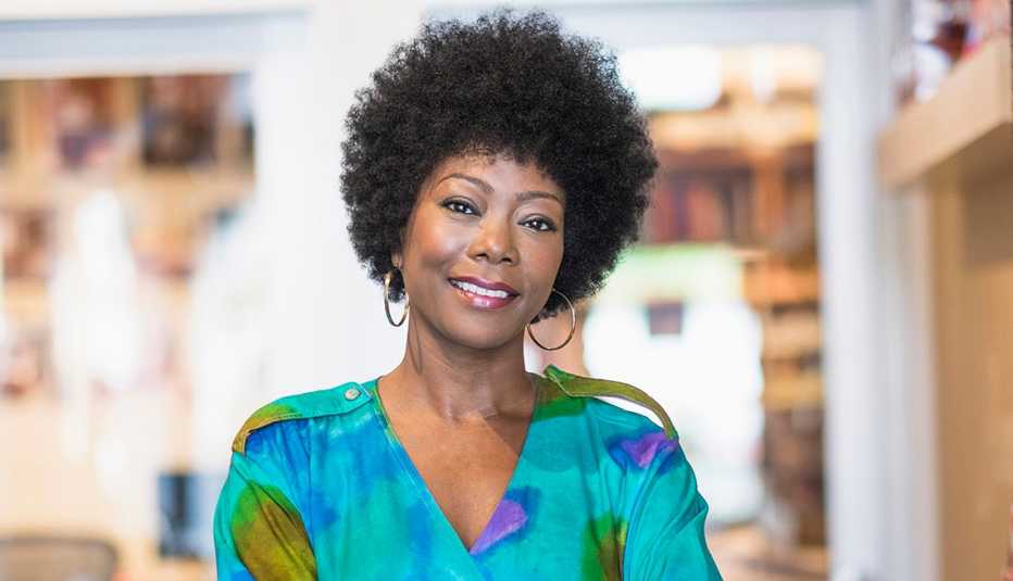 Una mujer con cabello rizado natural sonriendo.