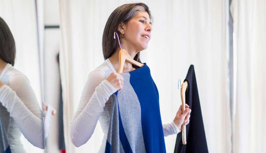 Una mujer comparando camisas antes de comprar.