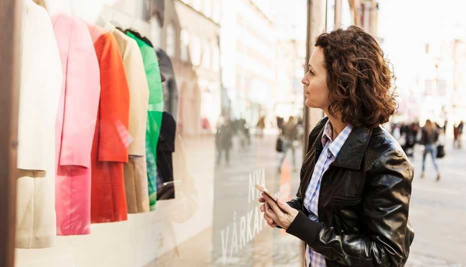 Una mujer mirando la vitrina de una tienda.
