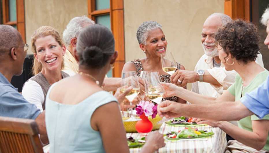 Grupo de adultos mayores cenando en la mesa.