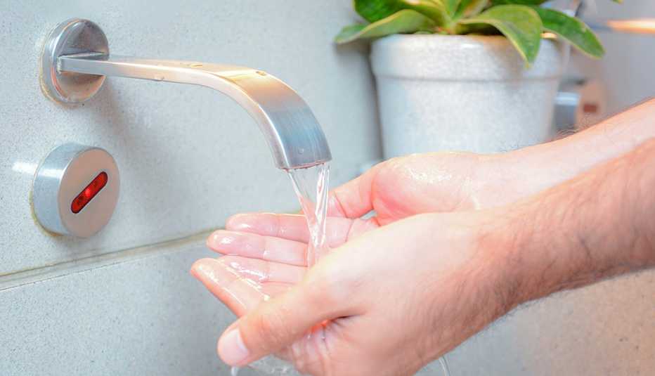 Manos debajo de un grifo mientras cae el agua