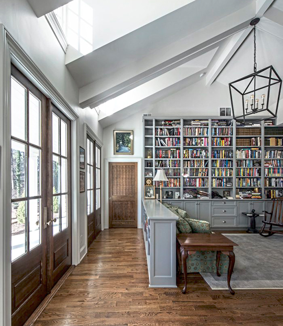 Interior de una casa con techos altos con una biblioteca