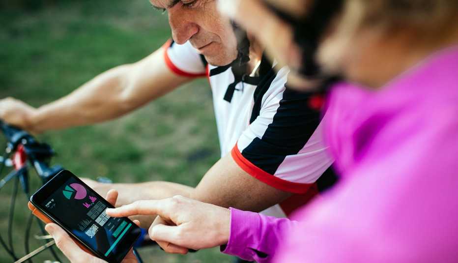 Pareja en bicicleta observa una aplicación en su teléfono