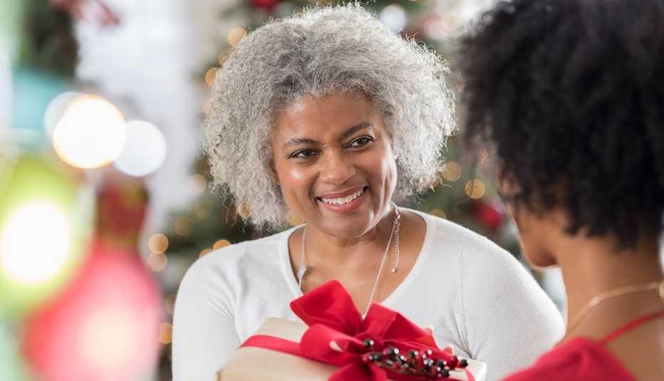 Una mujer recibe un regalo navideño..