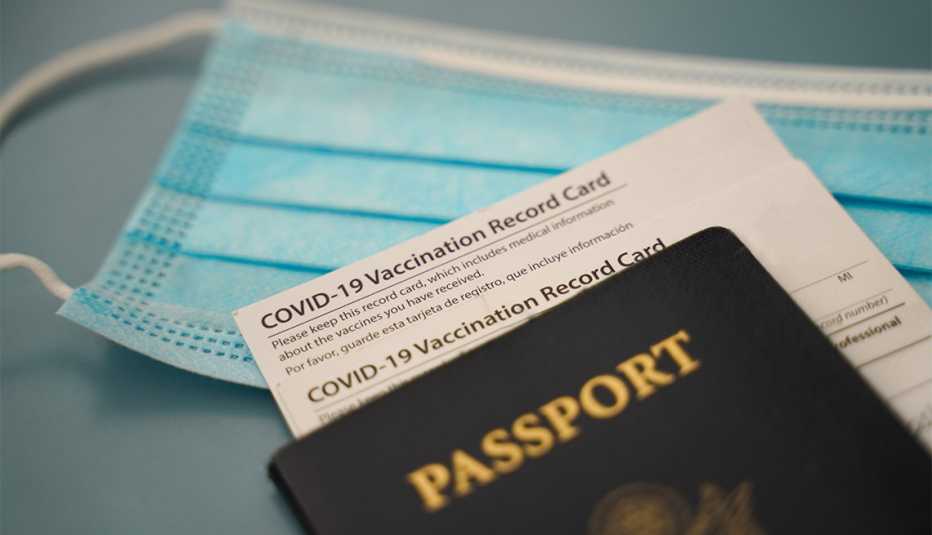 Tarjeta de vacuna covid, pasaporte estadounidense y máscara quirúrgica