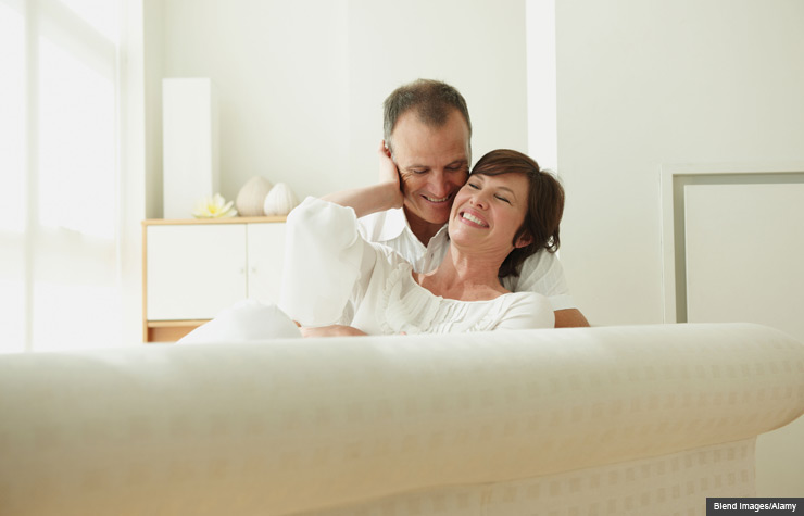 Pareja acariciándose en un sofa - Una guía a las relaciones sexuales después del cáncer de mama.