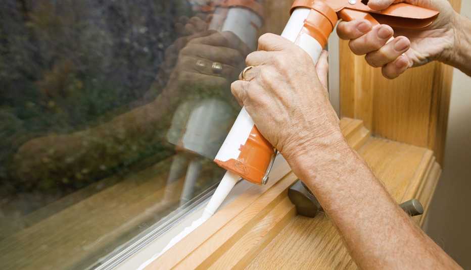 Persona sellando una ventana
