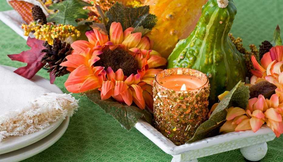 Bandeja con flores, calabazas y una vela