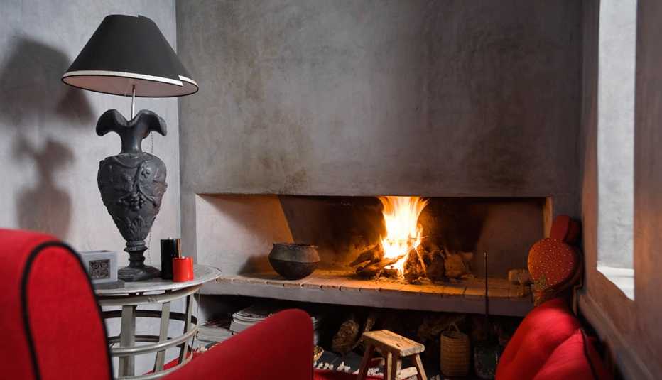 Un sillón rojo frente a una chimenea