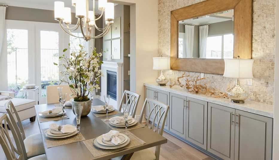 Salón comedor con mobiliario gris y objetos decorativos blancos