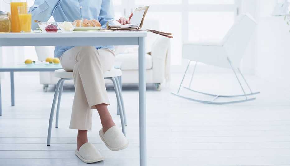 Cómo prevenir caídas en la cocina - Mujer desayuna en la cocina