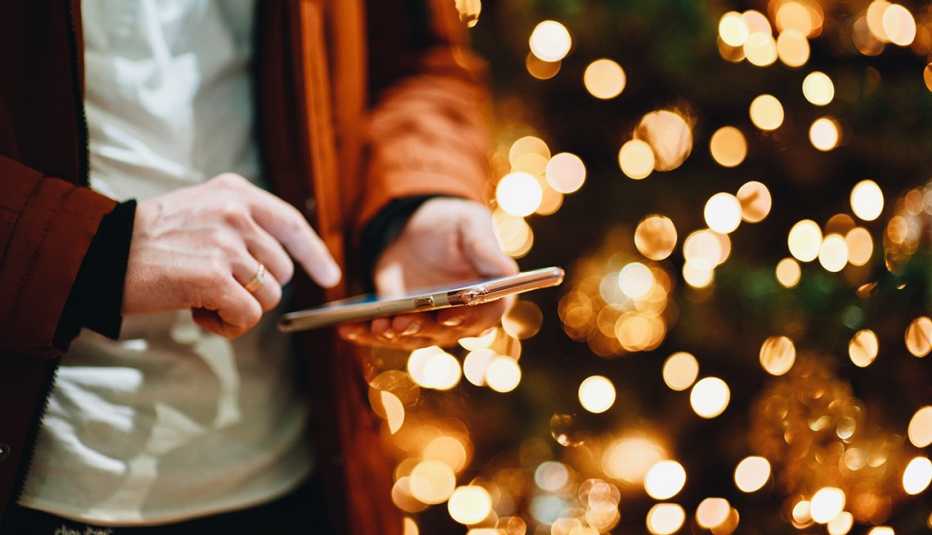 Hombre usa un teléfono para prender las luces de Navidad