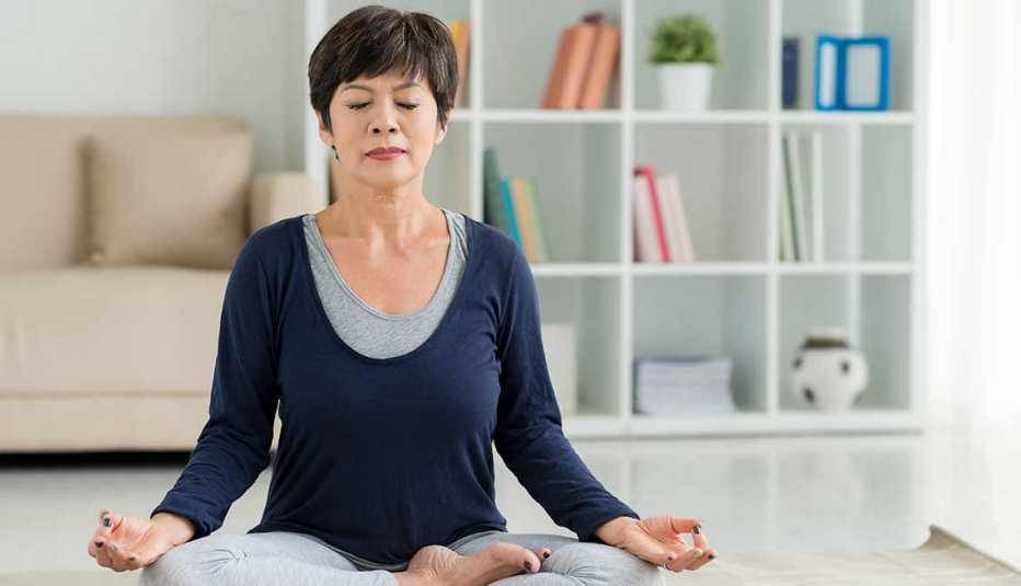 Una mujer meditando en una habitación iluminada