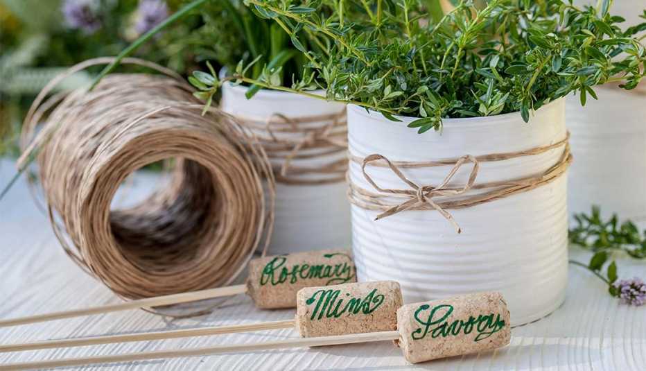 Dos latas blancas con plantas junto a elementos de decoración