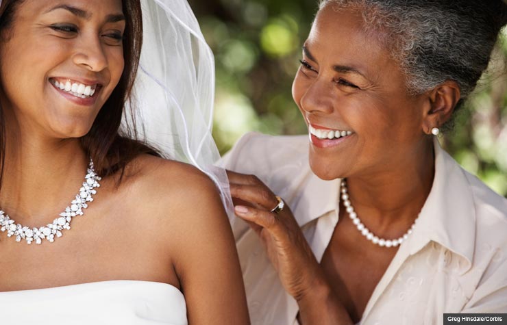 Madre sonriendo con su hija vestida de novia