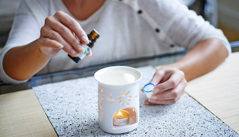 Mujer añadiendo aceite a un pebetero