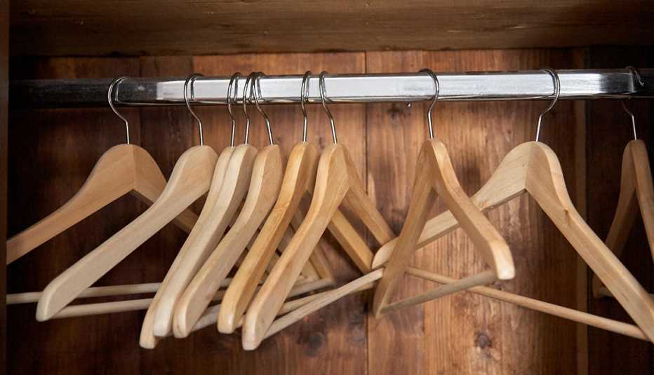 Varias perchas de madera colgadas en un closet vacío