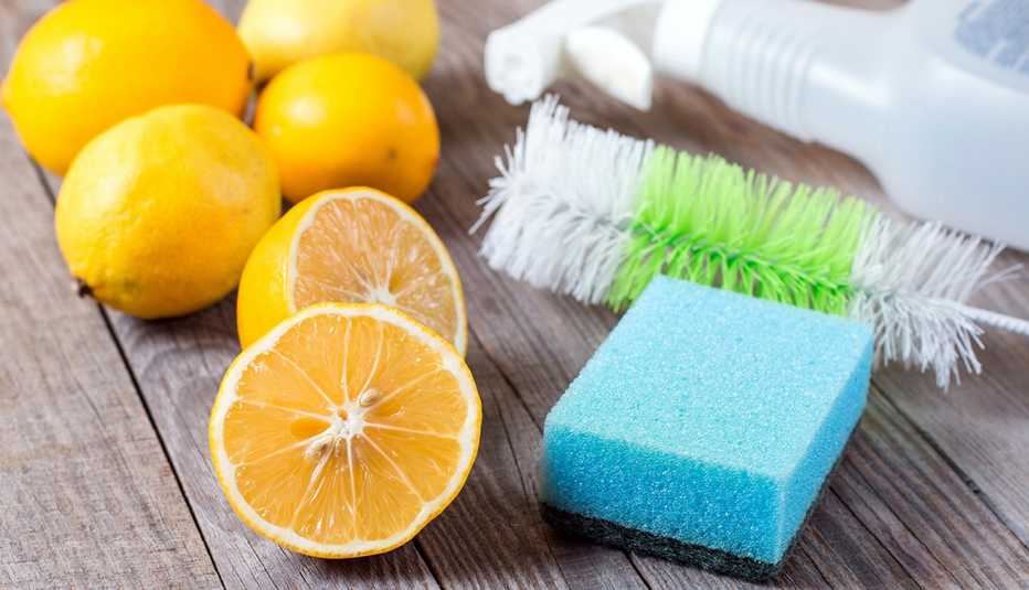 Limones sobre una mesa con utensilios de limpieza