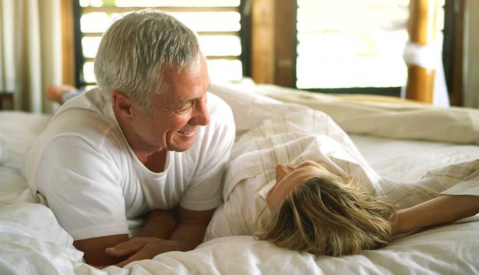 Pareja acostada en una cama hablando entre ellos