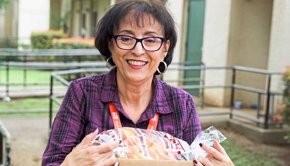 Mary Lustri sostiene una caja de comestibles