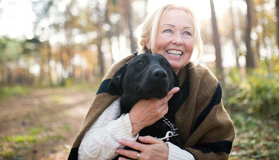 Mujer abraza a un perro de color negro