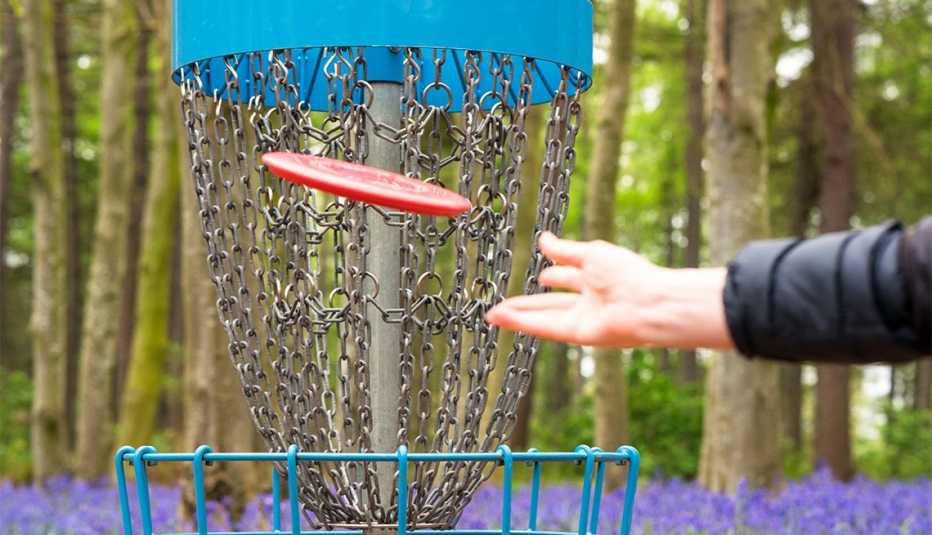 Un jugador lanza un disco rojo a corta distancia hacia la canasta