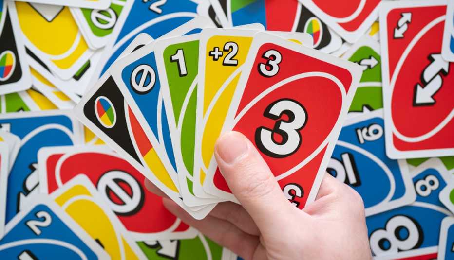 Mano sujeta unas cartas del juego Uno