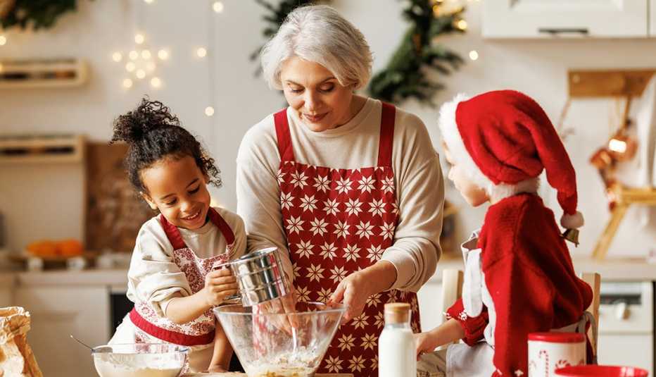Abuela horneando galletas con sus dos nietos