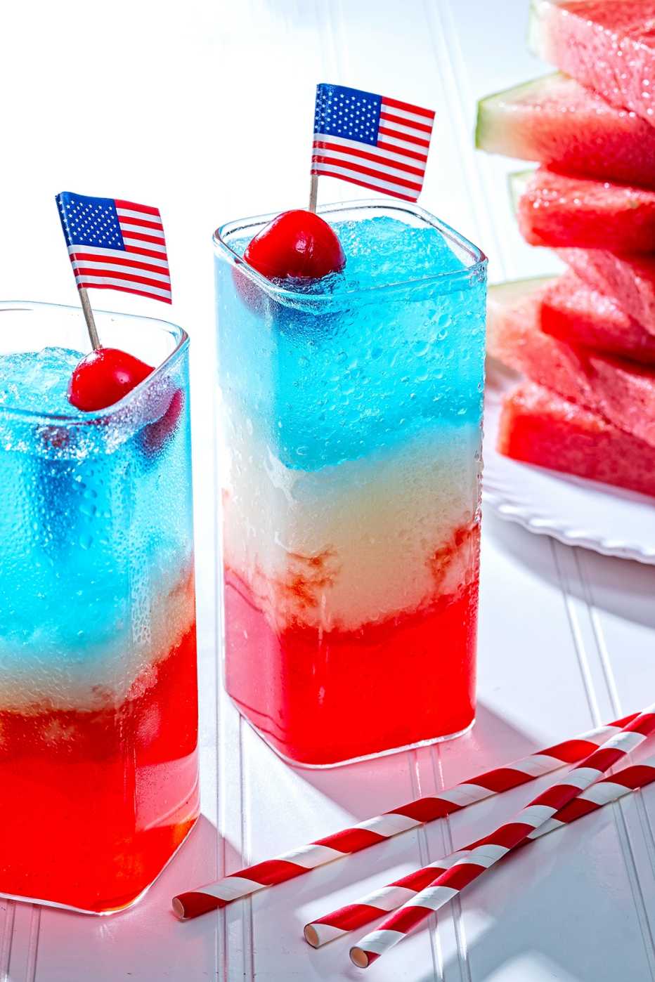 Dos vasos con bebidas sin alcohol y la bandera de EEUU sobre una cereza