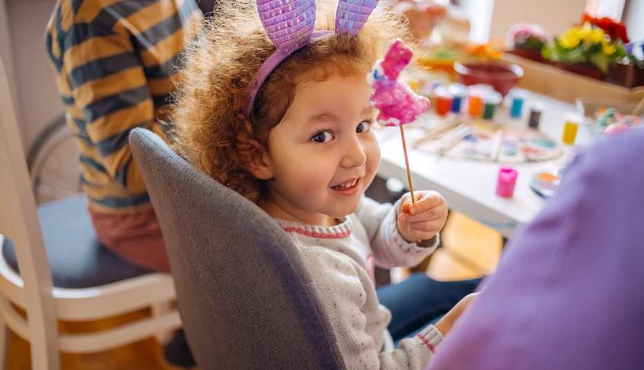 Niña pequeña que muestra un conejito de Pascua
