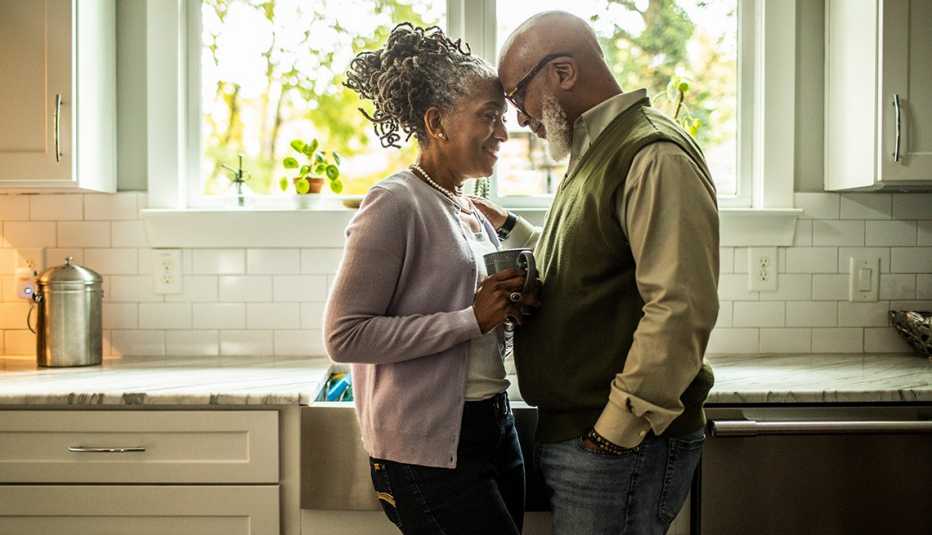 Una pareja, en la cocina de su hogar, se muestra cariño