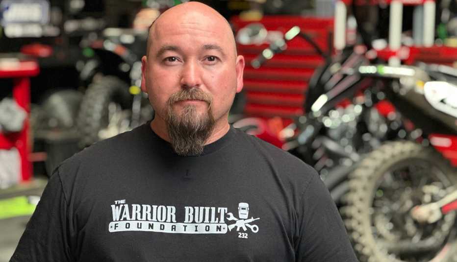 Nick Hamm en un garaje  con una camisa de la Warrior Built Foundation.