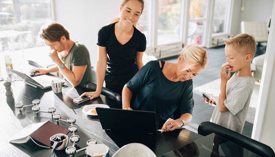 Familia usando dispositivos tecnológicos en el comedor