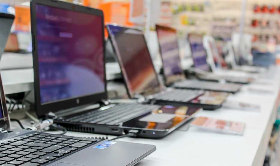 Línea de computadores portátiles en una tienda de tecnología