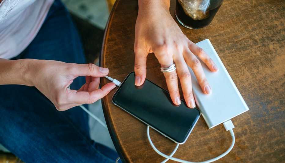 Mujer conectado su teléfono a una batería portatil