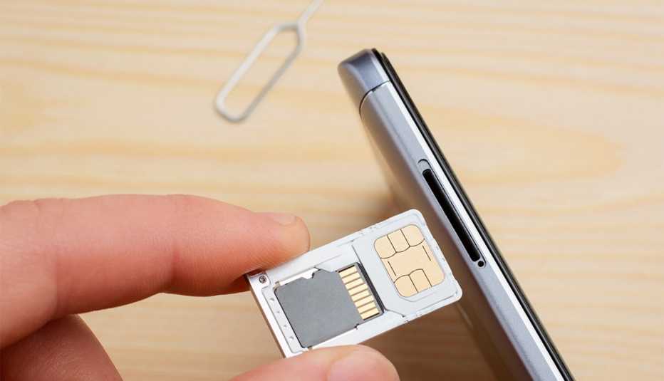 Persona sostiene la tarjeta SIM de un teléfono móvil