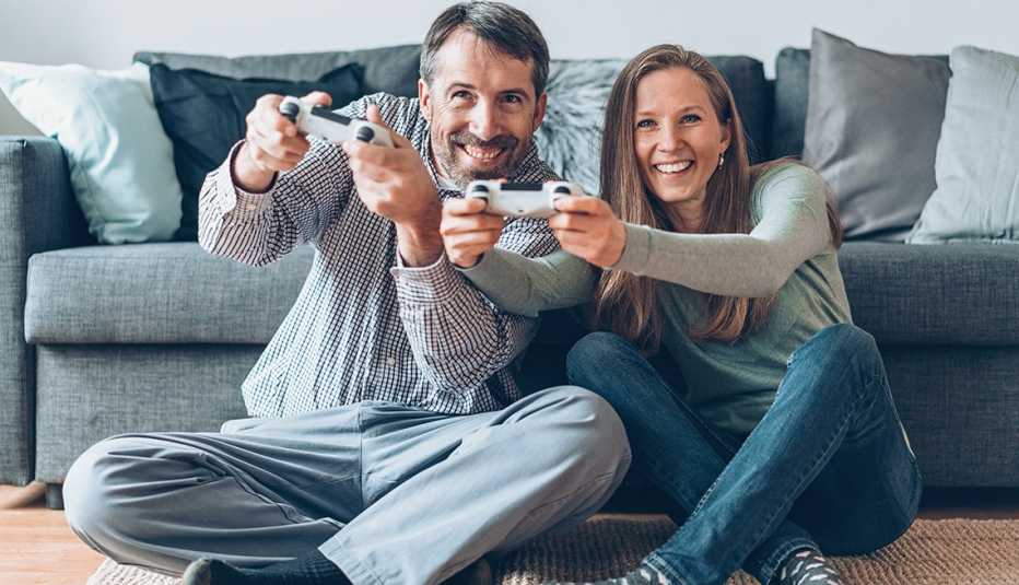 Pareja juega videojuegos en casa