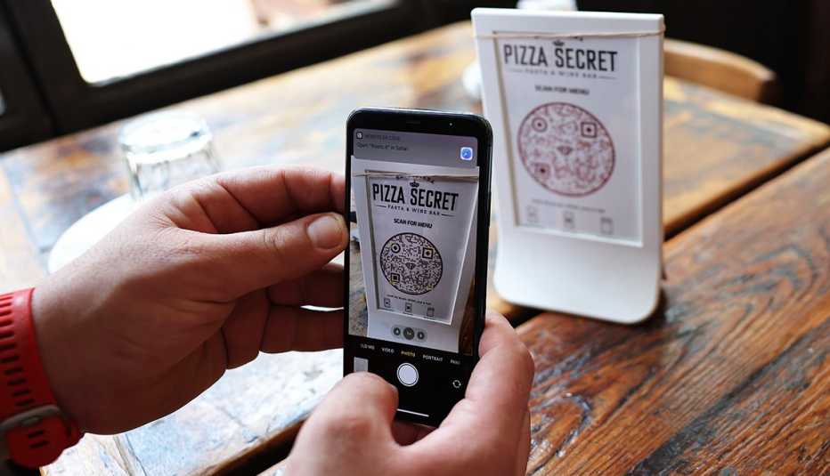 Persona usa un teléfono inteligente para escanear un menú