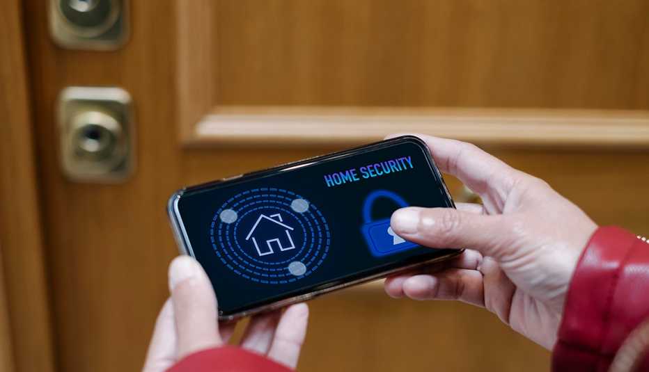 Una persona quita el seguro de su hogar desde un teléfono móvil