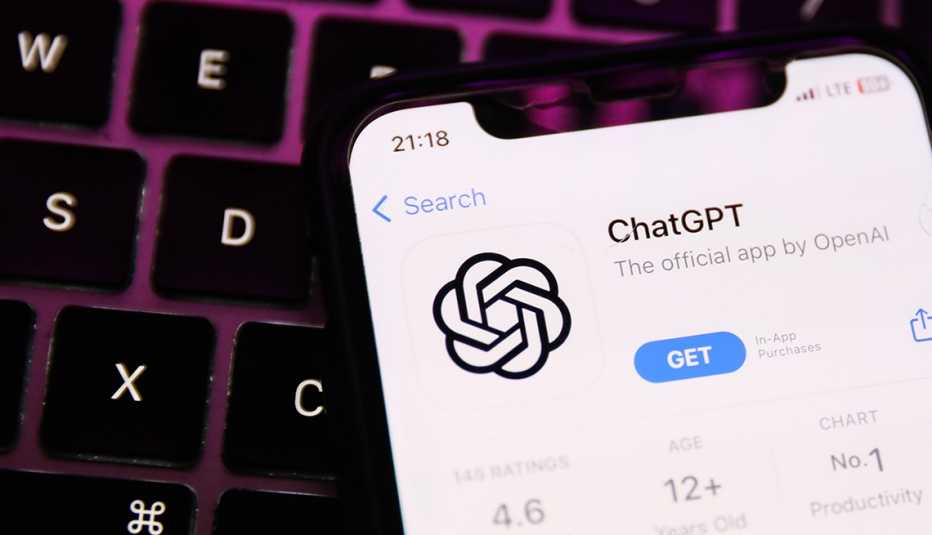 un teléfono inteligente con la página para descargar la aplicación de ChatGPT sobre un teclado de computadora