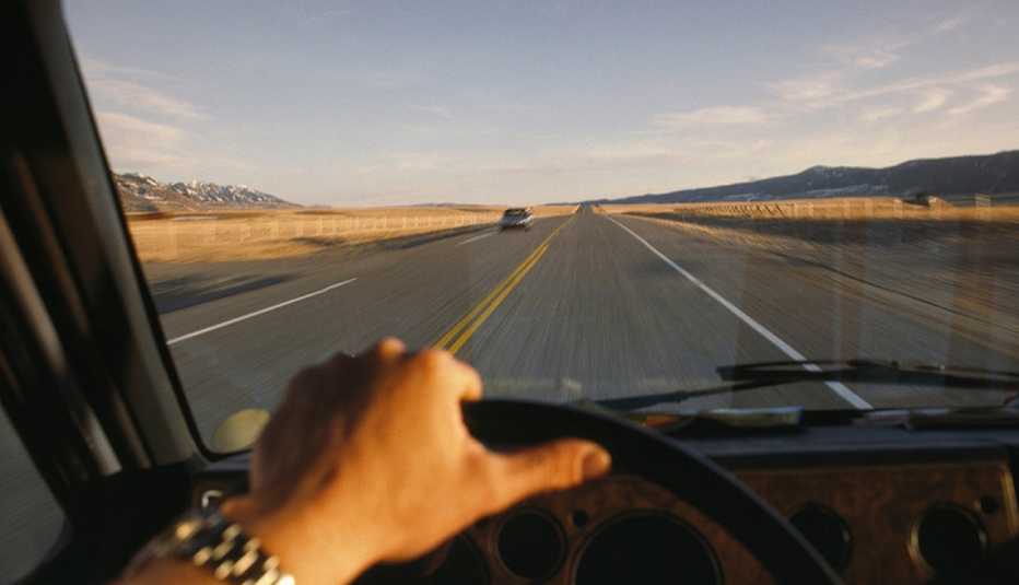 Mano de un hombre en el volante de un vehículo